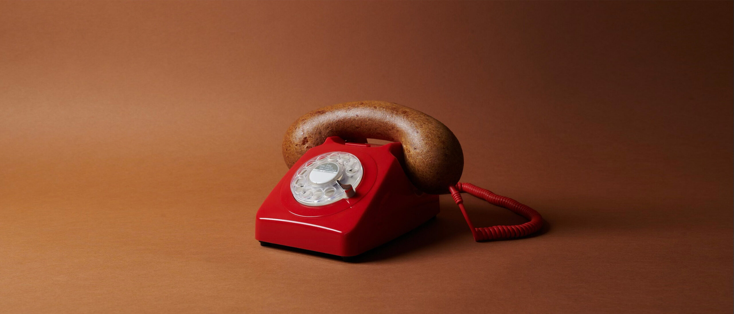 Rotary dial telephone with a loaf of bread as the earpiece.